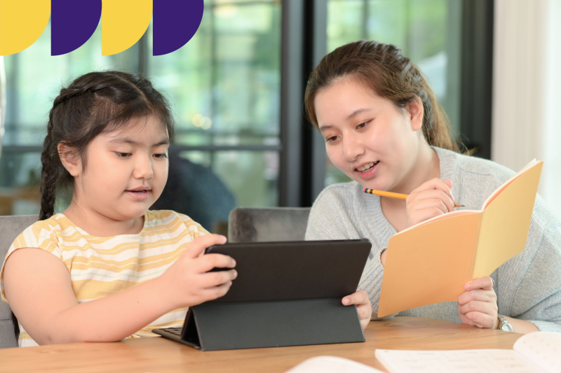 Parent working with student at laptop